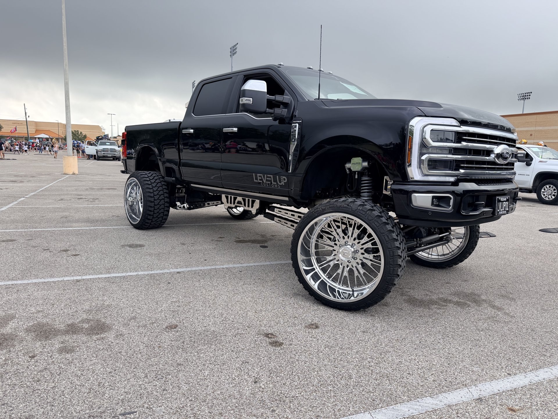Black Ford Super Duty show truck with suspension lift and chrome wheels, Level Up Customs, Alvin TX
